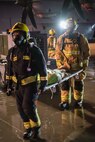 Firefighters from the 379th Expeditionary Civil Engineer Squadron and Qatar Emiri Air Force collaborate in a joint training exercise at Al Udeid Air Base, Qatar, Feb. 28, 2018. The exercise, a simulated response to a C-130 Hercules aircraft fire emergency, marks the first instance of the partner forces responding together in the same vehicles. (U.S. Air Force photo by Staff Sgt. Joshua Horton)