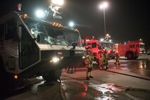 Firefighters from the 379th Expeditionary Civil Engineer Squadron and Qatar Emiri Air Force collaborate in a joint training exercise at Al Udeid Air Base, Qatar, Feb. 28, 2018. The exercise, a simulated response to a C-130 Hercules aircraft fire emergency, marks the first instance of the partner forces responding together in the same vehicles. (U.S. Air Force photo by Staff Sgt. Joshua Horton)