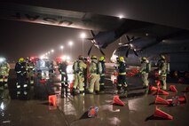 Firefighters from the 379th Expeditionary Civil Engineer Squadron and Qatar Emiri Air Force collaborate in a joint training exercise at Al Udeid Air Base, Qatar, Feb. 28, 2018. The exercise, a simulated response to a C-130 Hercules aircraft fire emergency, marks the first instance of the partner forces responding together in the same vehicles. (U.S. Air Force photo by Staff Sgt. Joshua Horton)