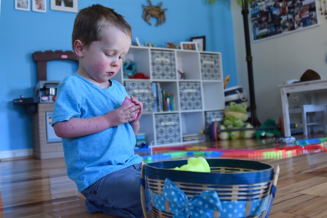 A baby boy plays with his toys.