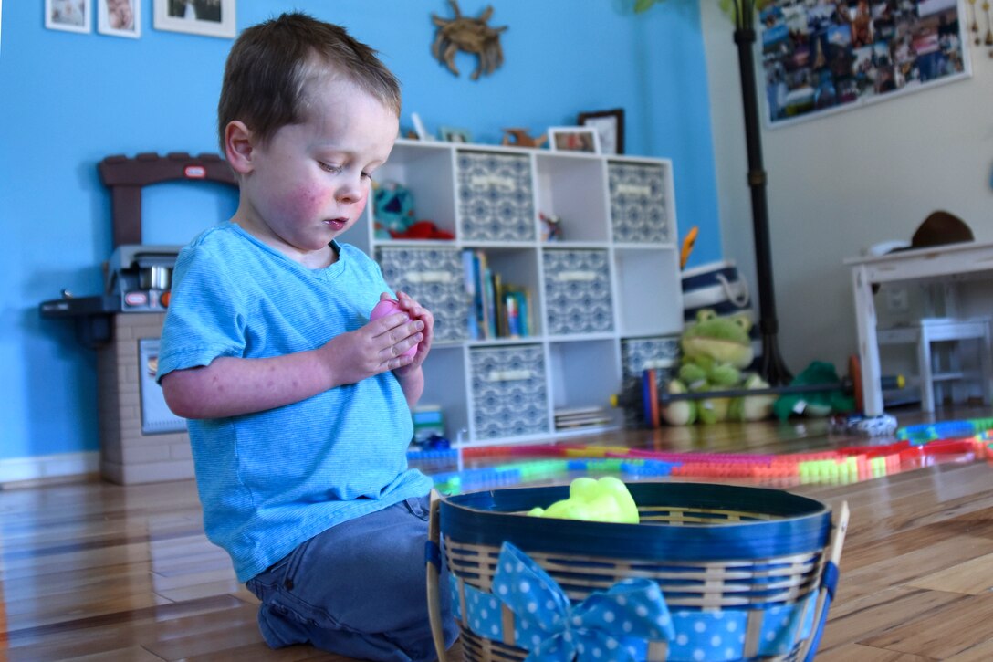 A baby boy plays with his toys.