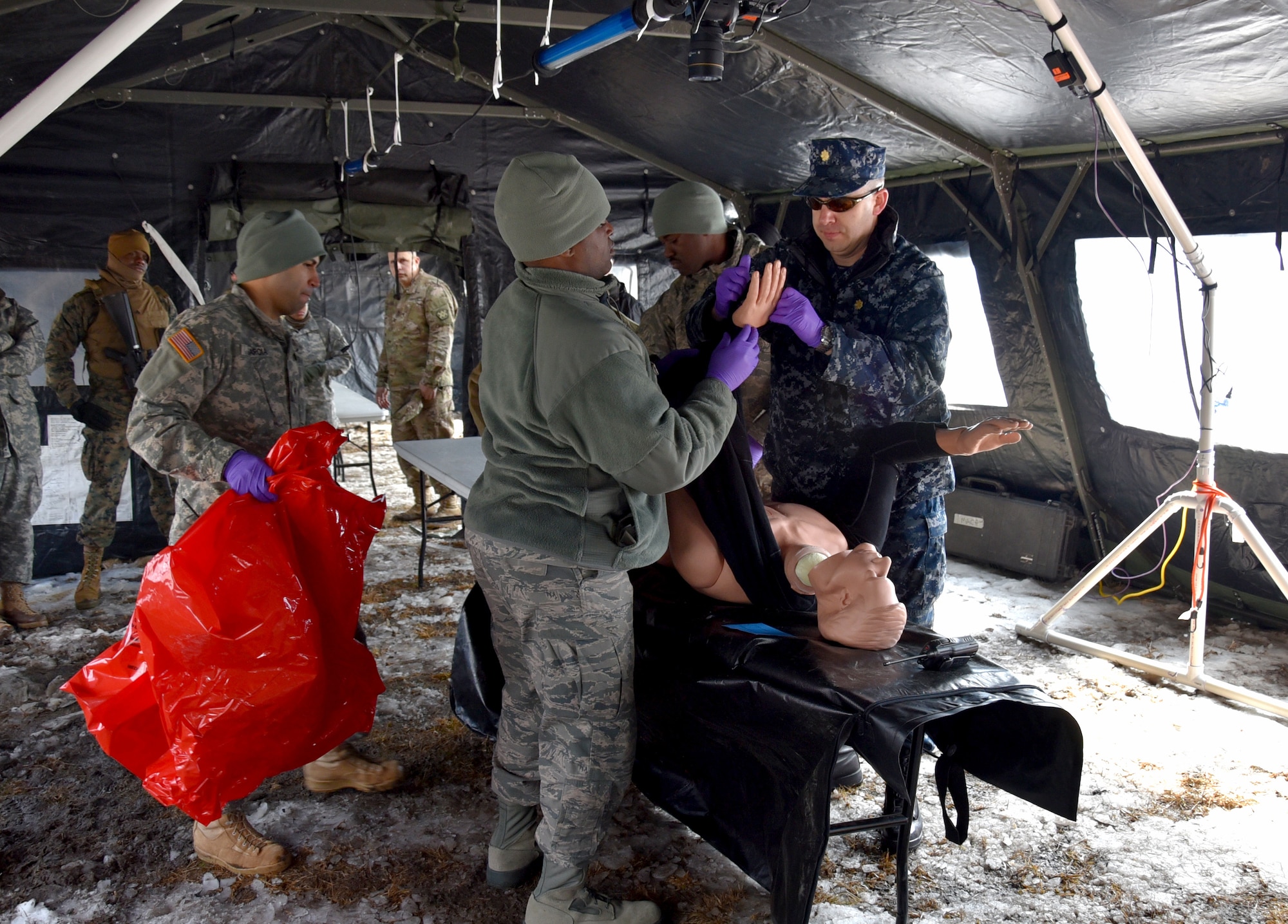 U.S. Navy Lt. Cmdr. Bryan Platt (right), Armed Forces Medical Examiner System forensic pathologist, demonstrates an examination at a simulated Mortuary Affairs Contaminated Remains Mitigation Site during Operation Joint Recovery exercise at Joint Base McGuire-Dix-Lakehurst, N.J., Mar. 10, 2018. Platt familiarized participants in contaminated remains recovery, processing and procedural guidance and provide an operational assessment. (U.S. Air Force photo by Tech. Sgt. Robert M. Trujillo)