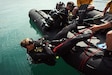 Specialist Matthew Fedewa and Sgt. Trevin Currey of the 74th Engineer Dive Detachment conduct a back-roll off of a combat rubber raiding craft, Kuwait Naval Base, Kuwait, March 6, 2018.