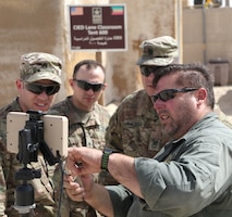 Mike Podplesky from ARCENT Readiness Training Center - Kuwait (ARTC-KU) demonstrates to 1st Security Forces Assistance Brigade (SFAB) Soldiers how to launch a PD-100 Nano Drone, Mar. 6, 2018. The Black Hornet weighs 18 grams and has a vertical ceiling of almost two miles.