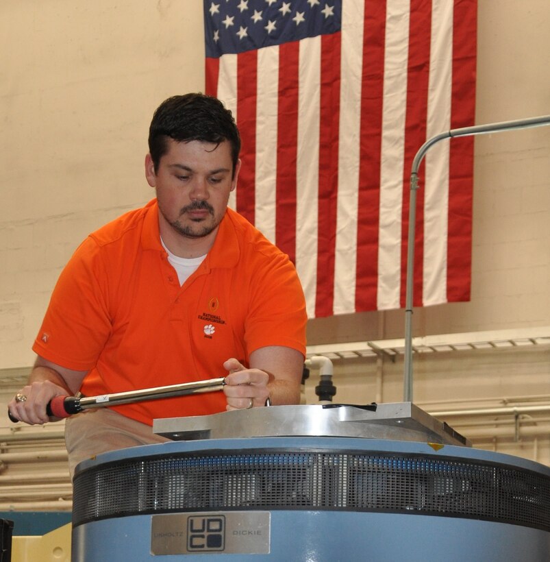 IMAGE: DAHLGREN, Va. - Naval Surface Warfare Center Dahlgren Division (NSWCDD) engineer Shawn Schneider mounts an adapter plate to an Unholtz-Dickie T-2000 electro-dynamic vibration system capable of providing over 24,000 pounds of force in vibration at frequencies up to and exceeding 3,000 hertz (cycles per second). These systems are used to replicate shock and vibration environments experienced by test items during their lifecycle to ensure that performance and safety are not compromised prior to use by the warfighter. NSWCDD announced on March 20 that Schneider won the 2018 Department of the Navy Award for Technical Excellence at a Test and Evaluation Facility or Range. The engineer was honored for extraordinary scientific and engineering contributions to the test and evaluation community in the area of multi-input-multi-output vibration test profiles.