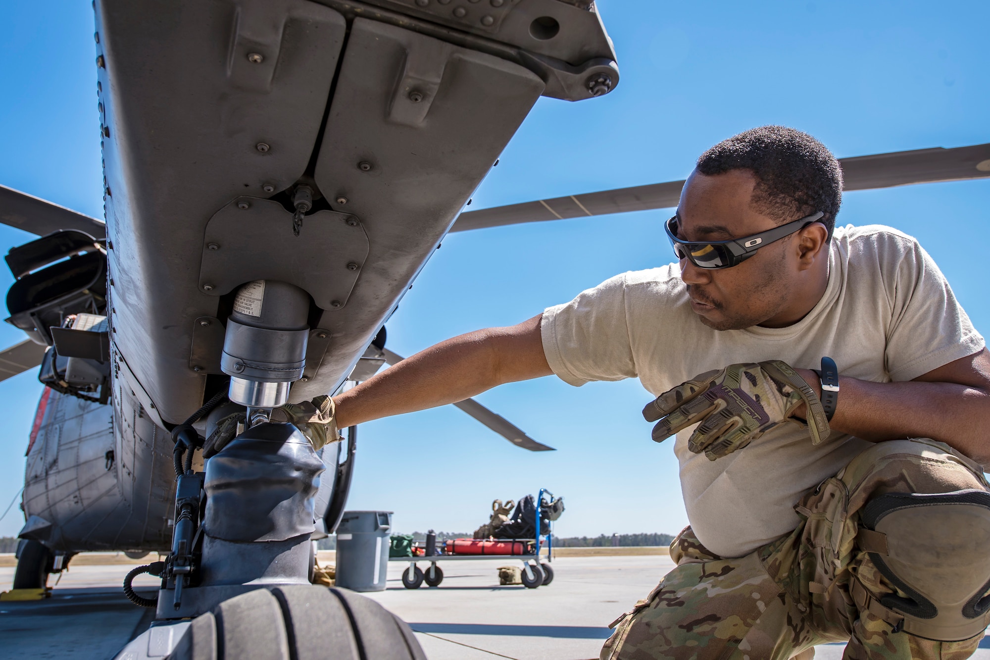 Senior Airman Latrell Solomon, 41st Rescue Squadron (RQS) special missions aviator, inspects the landing gear of an HH-60G Pave Hawk, March 15, 2018, at Moody Air Force Base, Ga.  Airmen from the 41st RQS and 723d Aircraft Maintenance Squadron conducted pre-flight checks to ensure that an HH-60G Pave Hawk was fully prepared for a simulated combat search and rescue mission.  (U.S. Air Force photo by Airman Eugene Oliver)