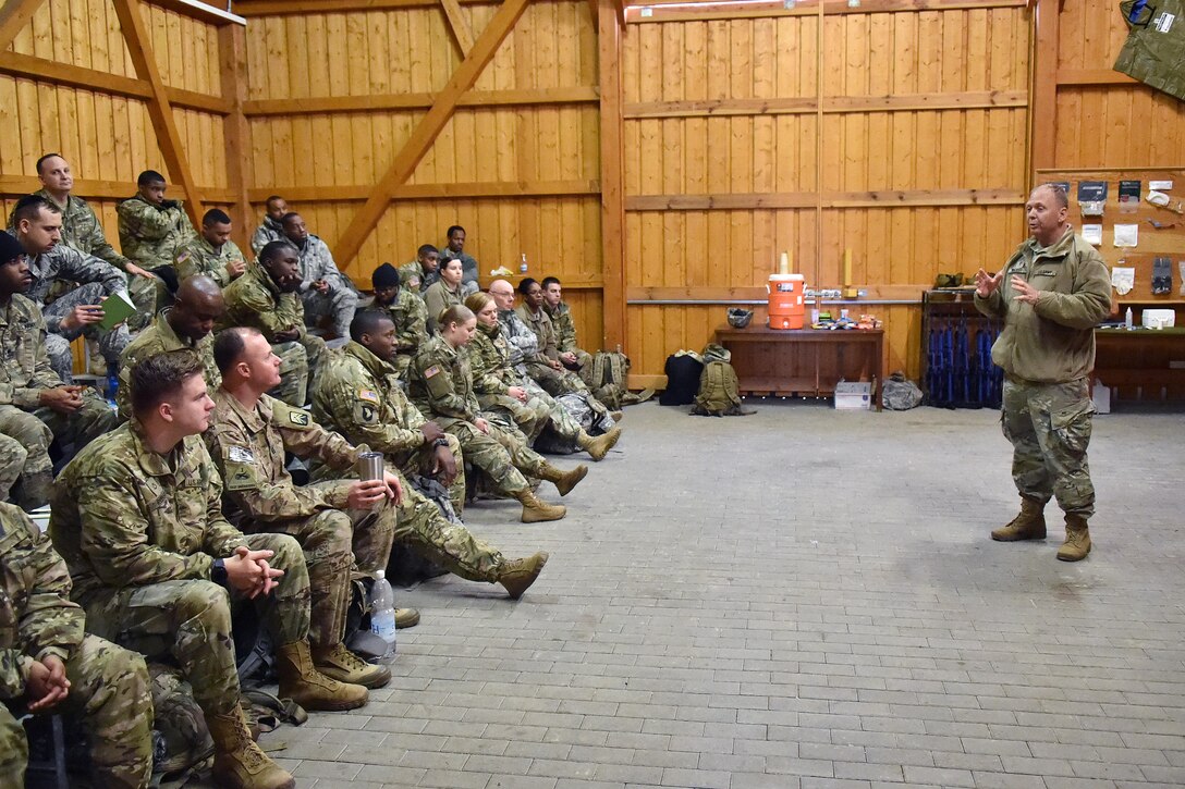 An instructor briefs soldiers on medical course criteria.