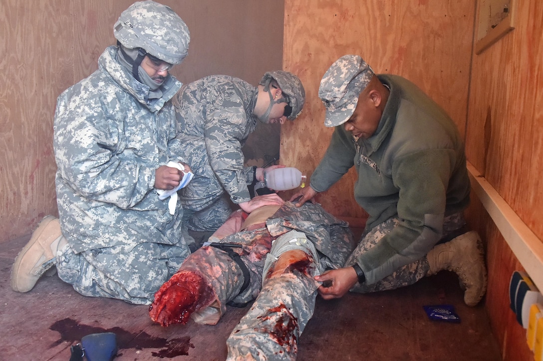 Soldiers give first aid to a simulated casualty.