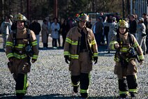 Airman 1st Class Chase Groh, right, Matthew Perreira, and Airman 1st Class Mack Lewis, 23d Civil Engineer Squadron (CES) firefighters, walk back to the aircraft rescue firefighting vehicles after briefing community leaders, March 15, 2018, at Moody Air Force Base, Ga. Firefighters from the 23d CES conducted the exercise to demonstrate aircraft rescue firefighting capabilities to community leaders and Moody’s honorary commanders. (U.S. Air Force photo by Airman 1st Class Erick Requadt)