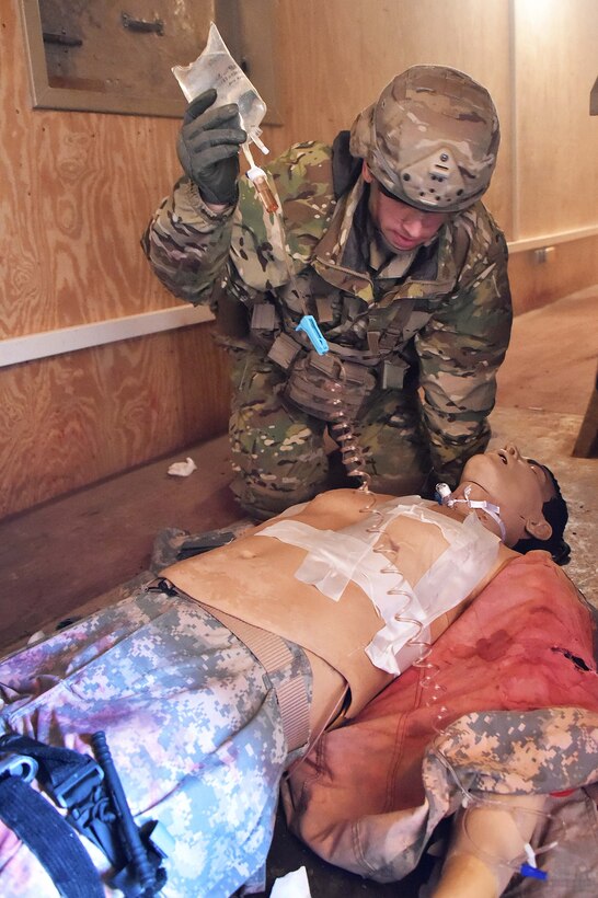 A soldier applies medical aid to a simulated casualty.