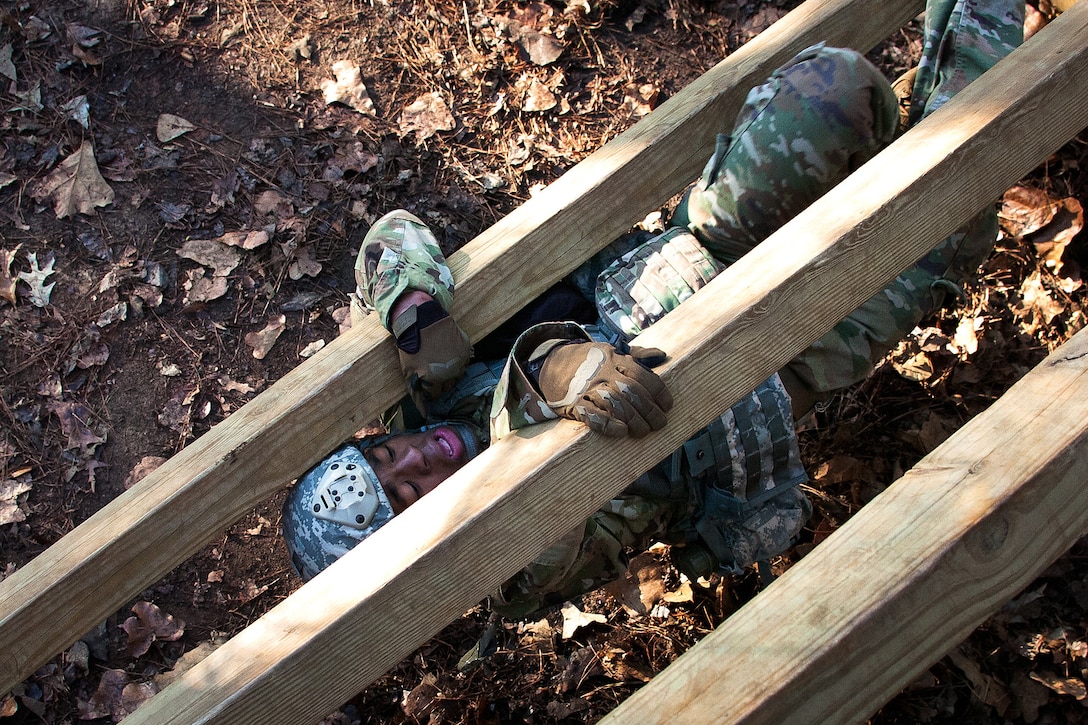 A soldier negotiates the weaver obstacle.