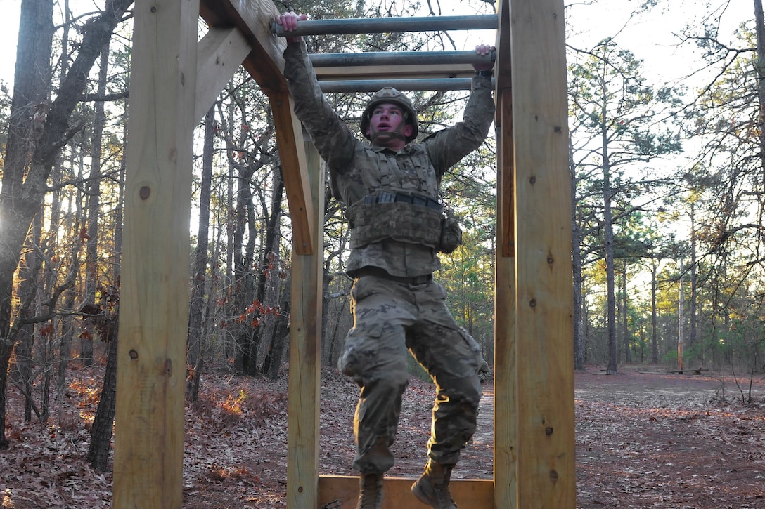 A soldier negotiates the horizontal ladder obstacle.