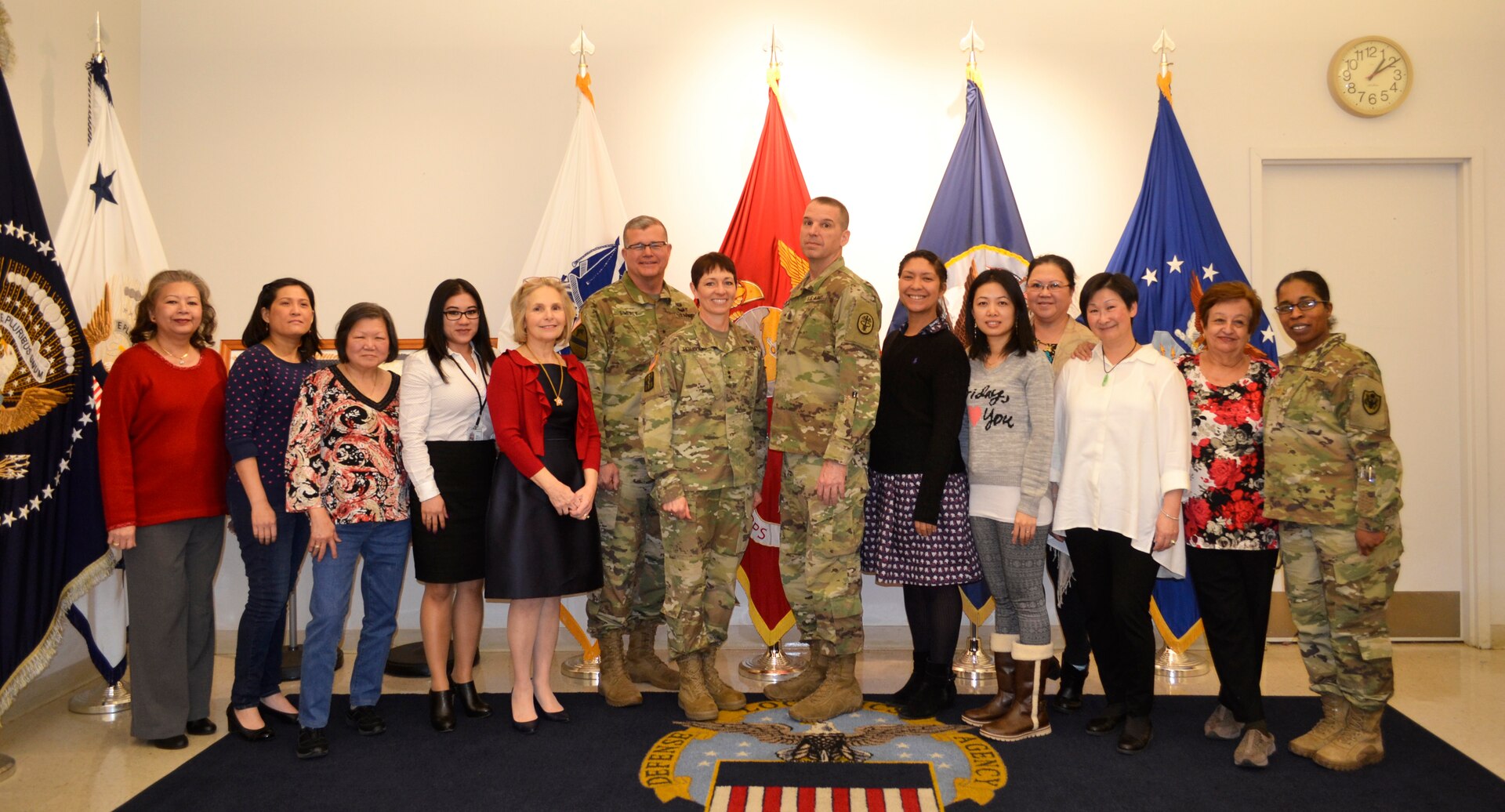Army Maj. Gen. Barbara Holcomb, U.S. Army Medical Research and Material Command commanding general, left center, and Command Sgt. Maj. David Rogers, right center, pose with Brig. Gen. Mark Simerly, DLA Troop Support commander, and the flag room staff at DLA Troop Support, March 16, 2018, in Philadelphia.