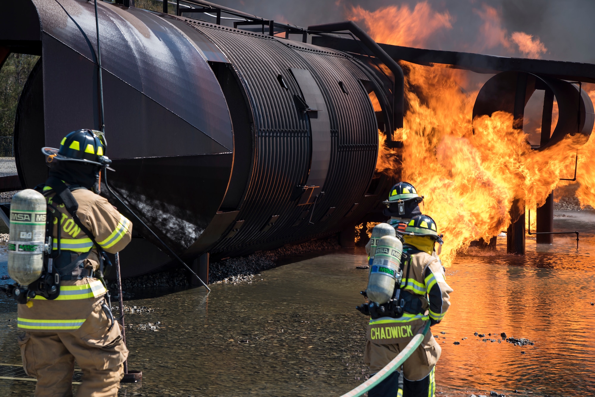 Firefighters from the 23d Civil Engineer Squadron (CES), work together to extinguish a fire on an aircraft simulator during a live-fire burn exercise, March 16, 2018, at Moody Air Force Base, Ga. Firefighters from the 23d CES conducted the exercise to demonstrate their firefighting capabilities to community leaders and Moody’s honorary commanders. (U.S. Air Force photo by Airman Eugene Oliver)