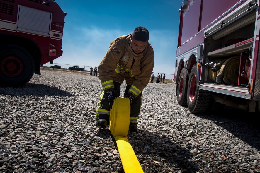 A firefighter from the 23d Civil Engineer Squadron rolls up a hose, following a live-fire burn exercise, March 16, 2018, at Moody Air Force Base, Ga. Firefighters from the 23d CES conducted the exercise to demonstrate their firefighting capabilities to community leaders and Moody’s honorary commanders. (U.S. Air Force photo by Airman Eugene Oliver)