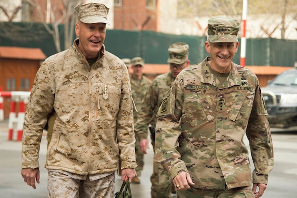 Two U.S. military leaders walk together in Afghanistan.