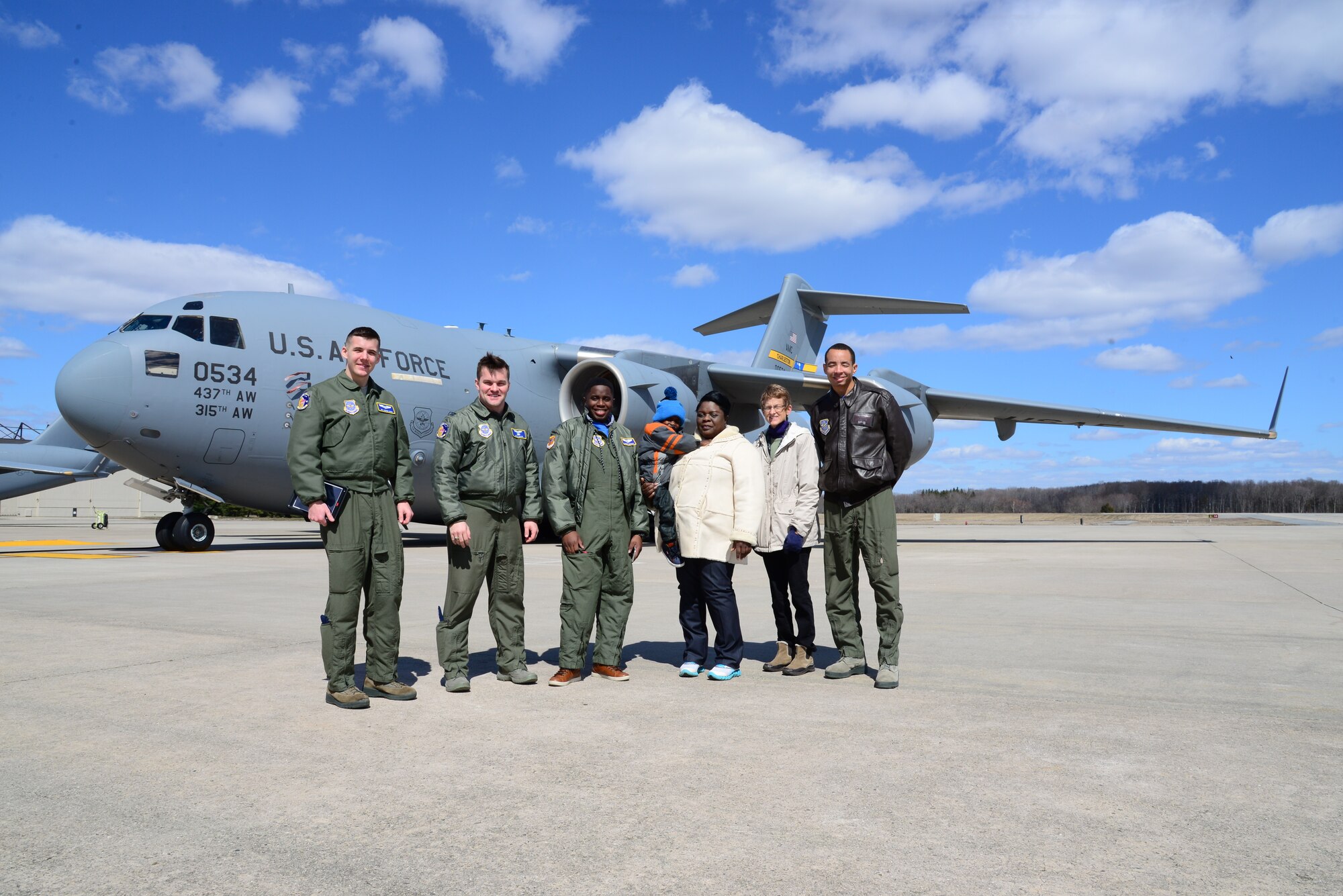 Members of the 3rd Airlift Squadron stand in front of a C-17 Globemaster III with Kareem Bennett (center) and his family March 16, 2018, at Dover Air Force Base, Del. Bennett was the second participant in the 3rd AS Pilot for a Day program. (U.S. Air Force photo by Staff Sgt. Aaron J. Jenne)