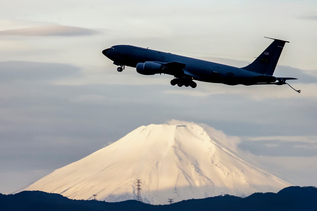 An aircraft takes off with a view of a mountain below.