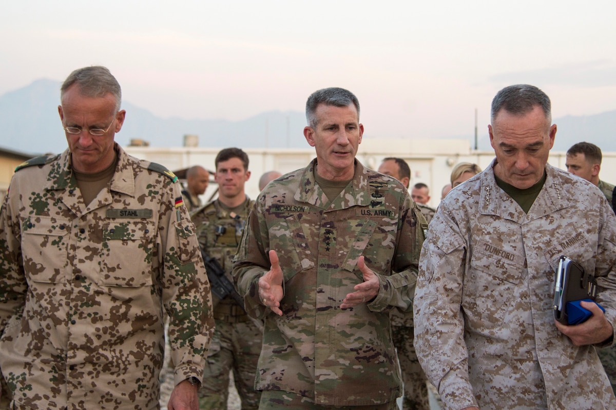 U.S. and foreign service members walk and talk in a line.