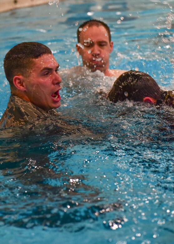 (From Left) U.S. Air Force Staff Sgt. Dajon Begin, 45th Intelligence Squadron full motion video imagery mission supervisor, U.S. Air Force Senior Master Sgt. Travis Shaw, Headquarters Air Combat Command Surgeon General pararescue programs manager, and U.S. Civil Air Patrol Cadet 1st Lt. Thomas Hall, practice water confidence exercises in Fort Eustis’ Anderson Field House at Joint Base Langley-Eustis, Virginia, March 6, 2018.