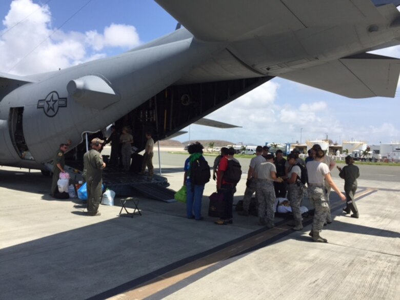 Members of a U.S. Air Force En Route Patient Staging System team from the 375th Medical Group based at Scott Air Force Base at Henry E. Rohlsen Airport, near Christiansted in St. Croix, U.S. Virgin Islands load the first patients onto an Air Force C-17 Globemaster III, Sept. 23, 2017. The team deployed to St. Croix to provide aeromedical evacuation support following Hurricane Maria. Patients began arriving at the airport less than an hour after the team arrived. (Photo by Lt. Col. Elizabeth Anderson-Doze)