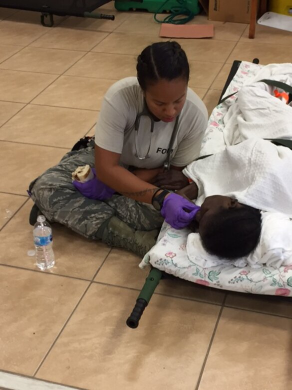 Staff Sgt. Tiffany Dewese, 375th Medical Group based at Scott Air Force Base, helps a patient eat during staging for aeromedical evacuation in St. Croix, U.S. Virgin Islands on Sept. 24, 2017. Dewese was part of a U.S. Air Force En Route Patient Staging System team that operated out of Henry E. Rohlsen Airport, near Christiansted in St. Croix to evacuate patients after Hurricane Maria. (Photo by Lt. Col. Elizabeth Anderson-Doze)