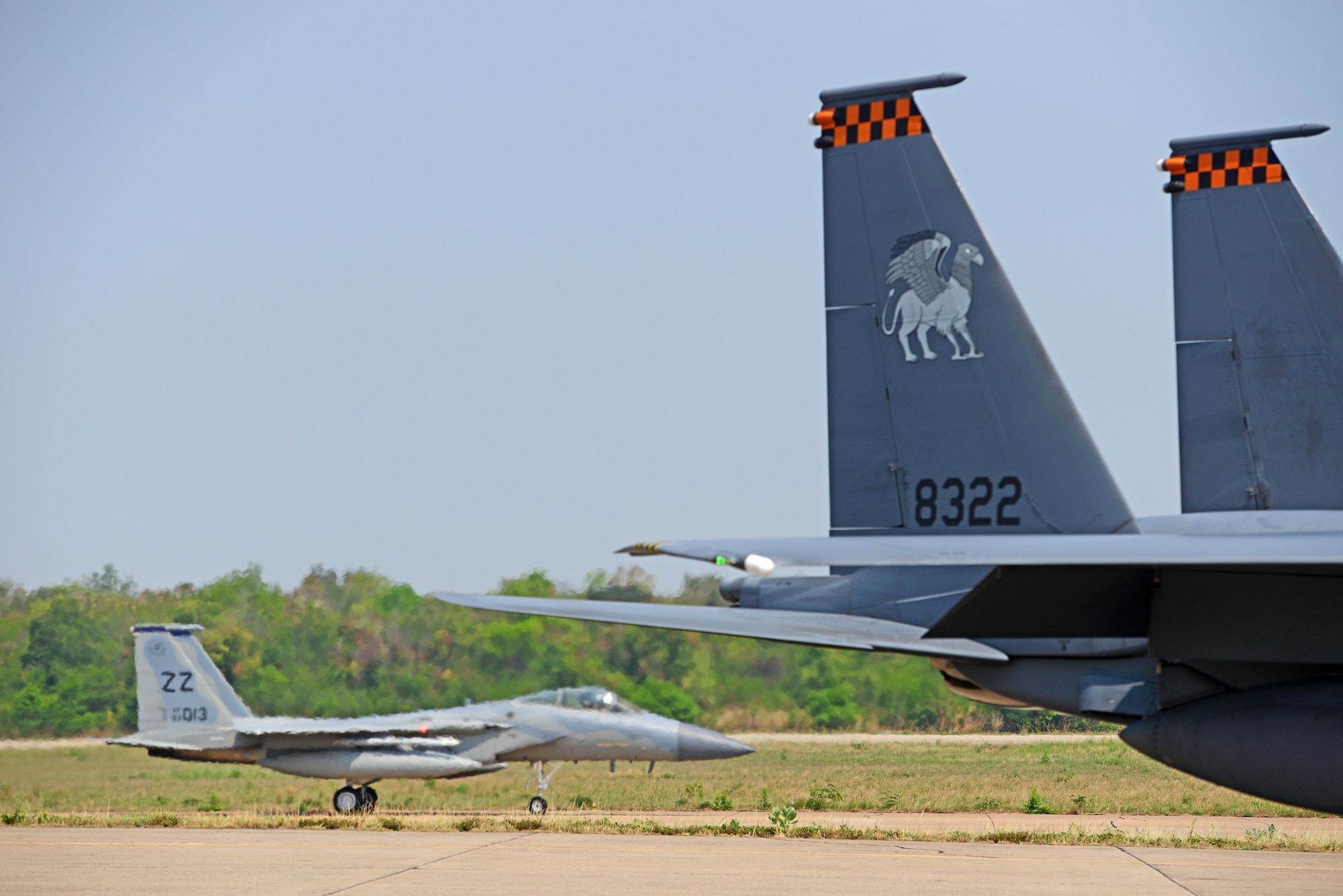 An F-15C Eagle from the 44th Fighter Squadron, Kadena Air Base, Japan, passes behind a Republic of Singapore Air Force F-15 during COPE TIGER 2018 at Korat Air Base, Thailand, March 20, 2018.