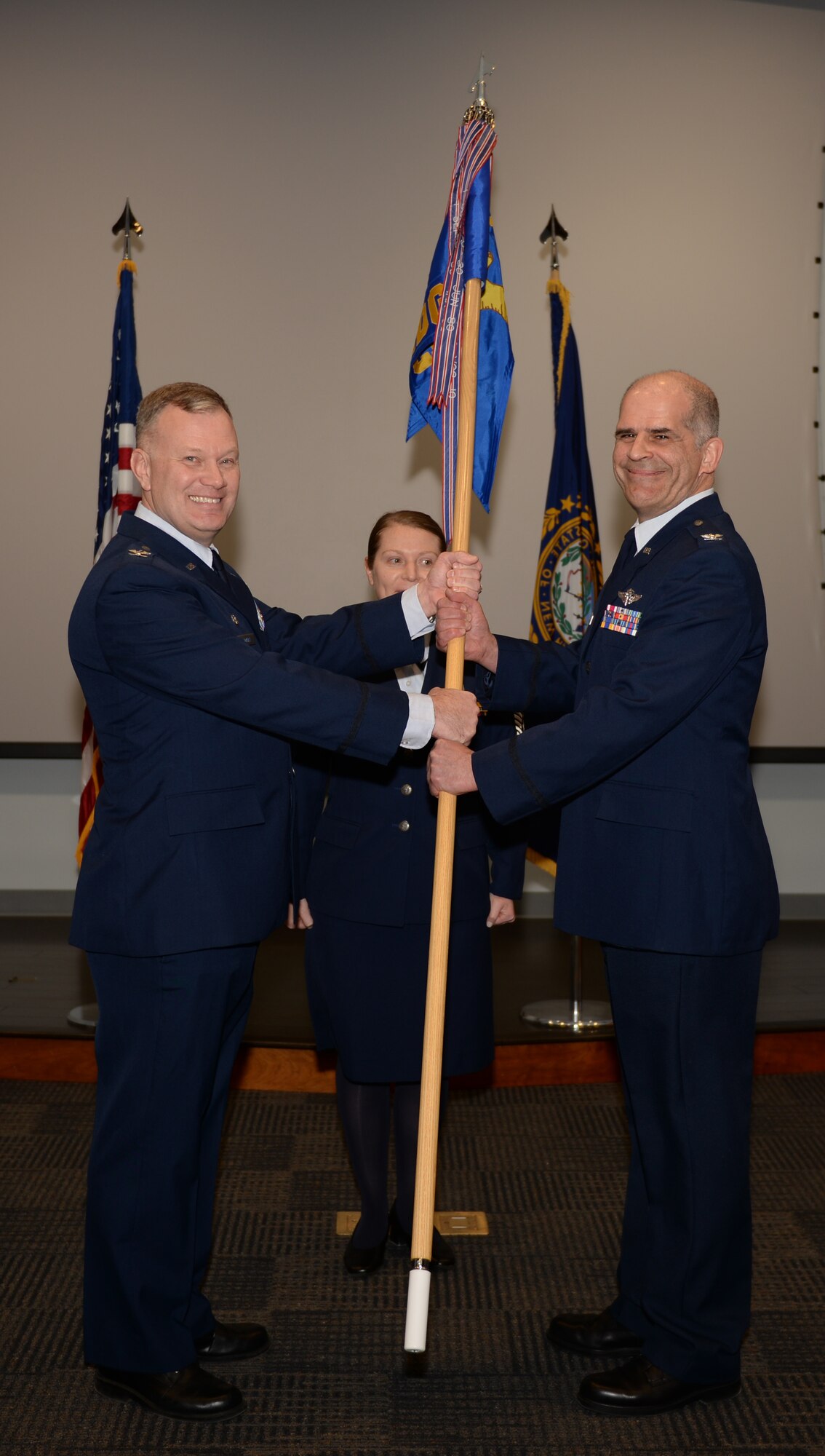 Col. John W. Pogorek passes a guidon to Col. John Mirabello on March 11, 2018, at Pease Air National Guard Base, N.H. Mirabello, the New Hampshire state air surgeon, assumed command of the 157th Medical Group. (N.H. Air National Guard photo by Senior Airman Ashlyn J. Correia)