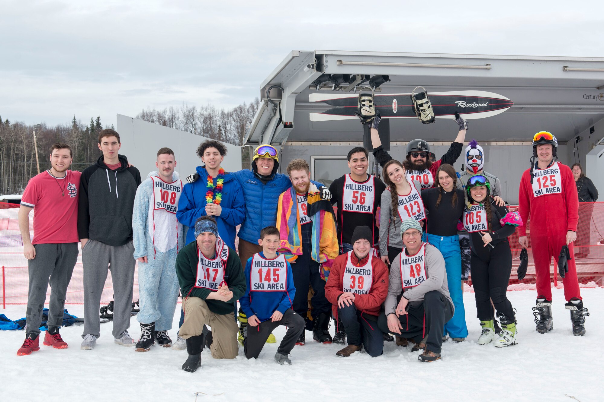 The 2018 Slush Cup participants stand as a group at the Joint Base Elmendorf-Richardson Hillberg Ski Area, March 18, 2018. The Slush Cup is a two-fold annual event celebrating the change in weather, consisting of skiers and snowboarders trying to make it across a man-made slush pond without falling.