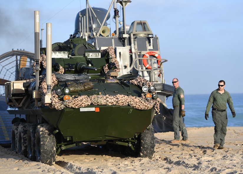 Marines unload vehicles from a landing craft.