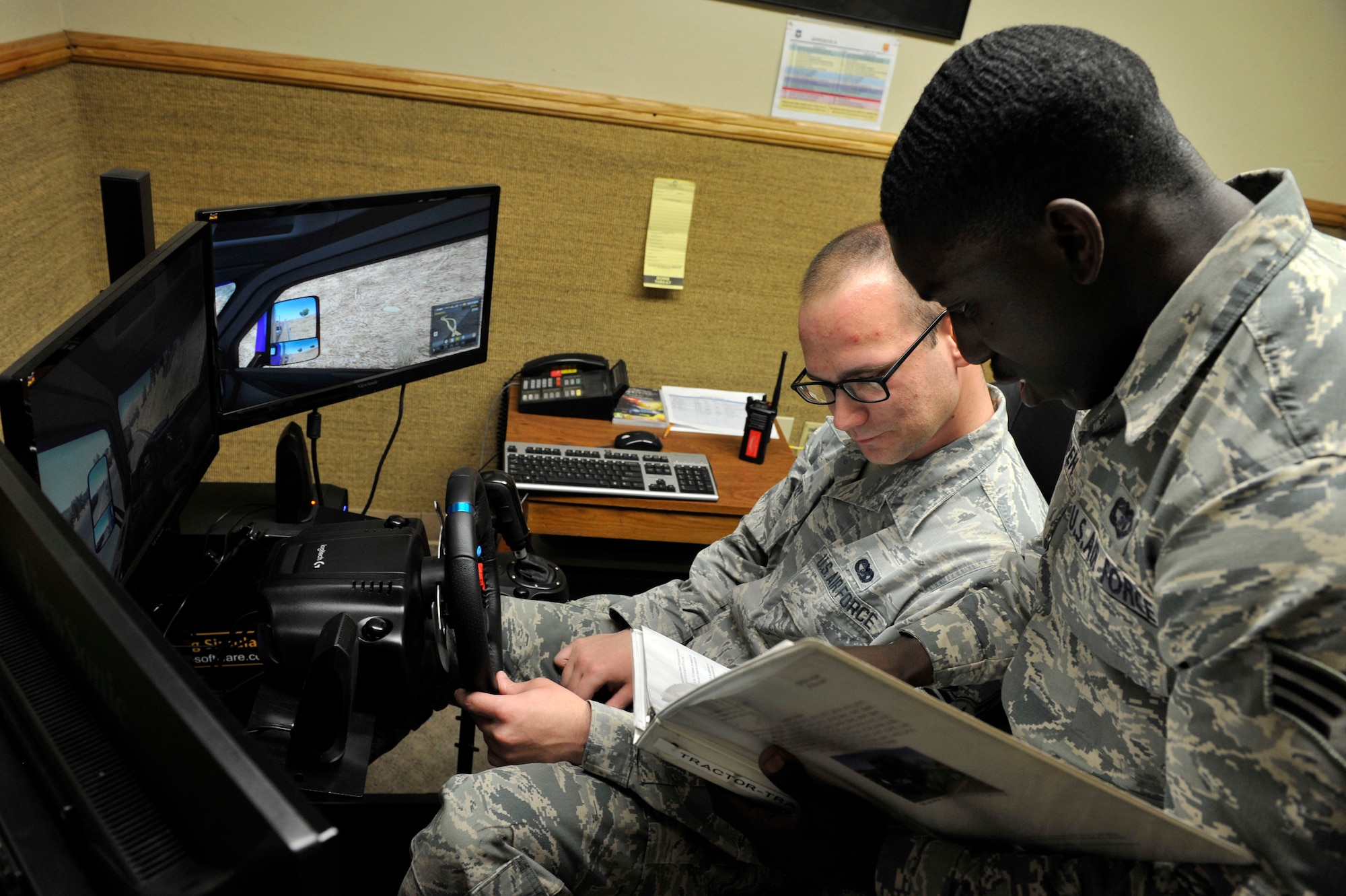 Airman 1st Class Larry Key, 56th Logistics Readiness Squadron vehicle operator dispatcher, and Senior Airman D’Andre Prempeh, 56th LRS vehicle operator trainer, review a lesson plan at Luke Air Force Base, Ariz., March 6, 2018.  The lesson plan supplements training on vehicle maneuvers practiced in the driving simulator.  
(U.S. Air Force Photo by Senior Airman Pedro Mota)