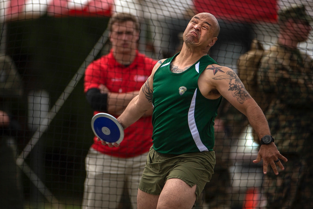 An athlete winds up to toss a discus.