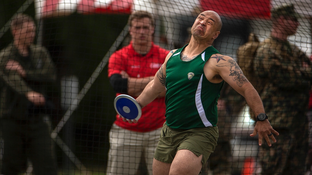 An athlete winds up to toss a discus.