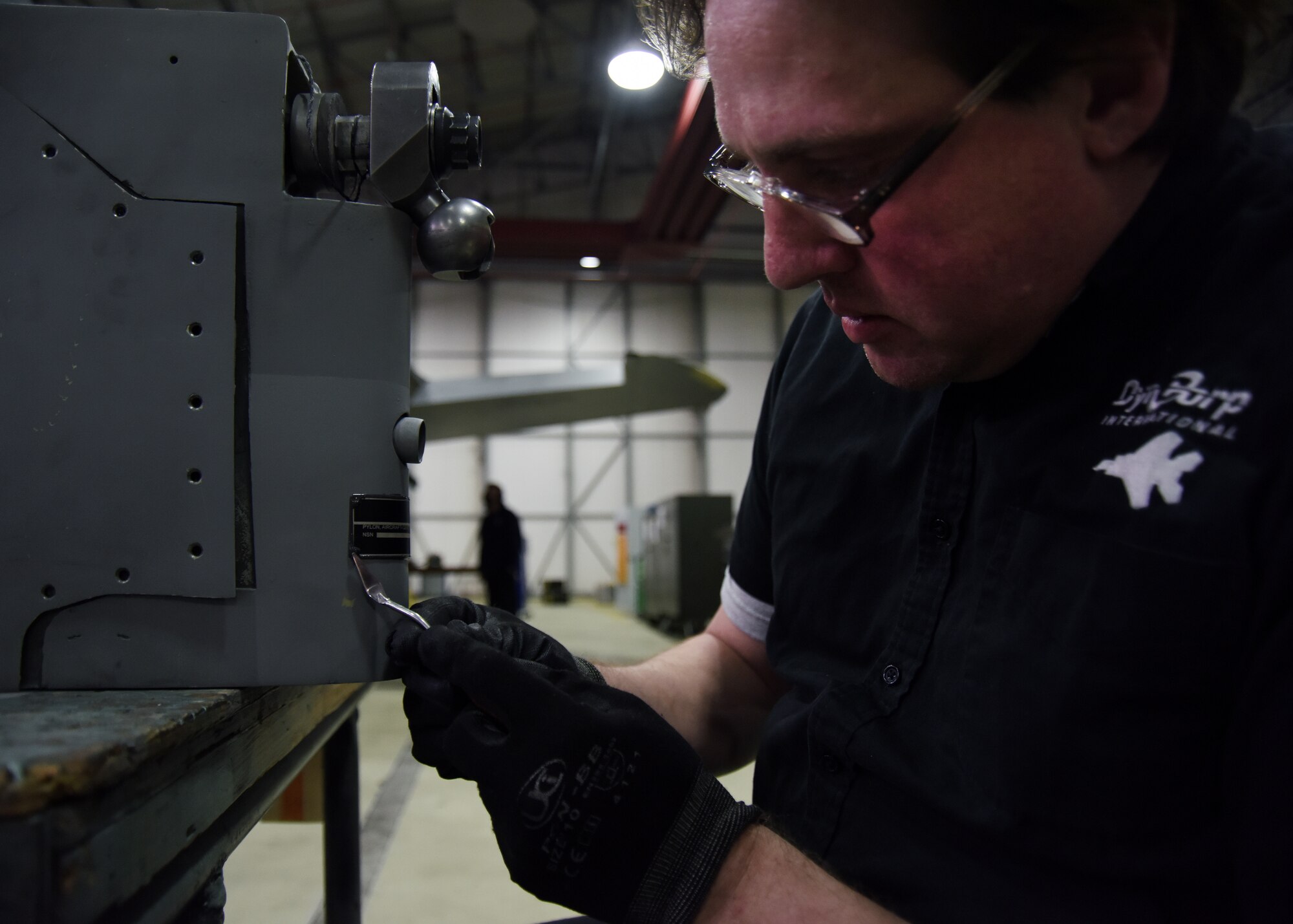 Brian Klemp, a contract field team aircraft structures mechanic, puts a new plate on a pylon at Royal Air Force Lakenheath, England, Feb. 23. The contractors conduct depot-level maintenance and repairs on F-15s that enable the 48th Fighter Wing to remain U.S. Air Forces in Europe and Air Forces Africa’s premiere combat wing. (U.S. Air Force photo/Senior Airman Abby L. Finkel)