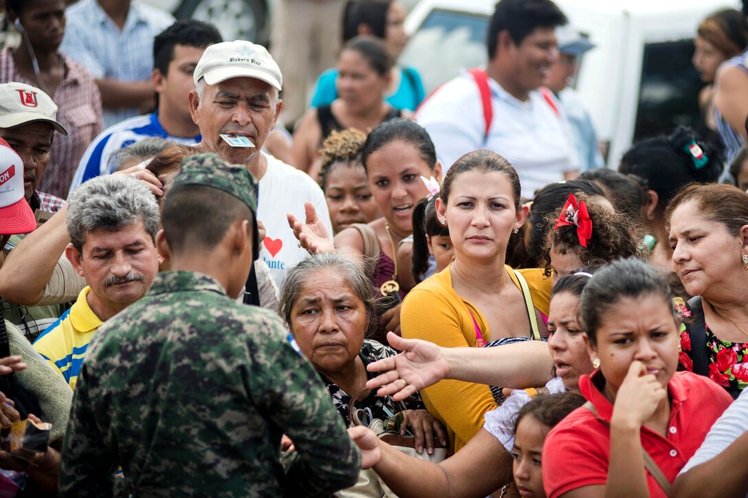 A Honduran woman waits in line with her daughter.