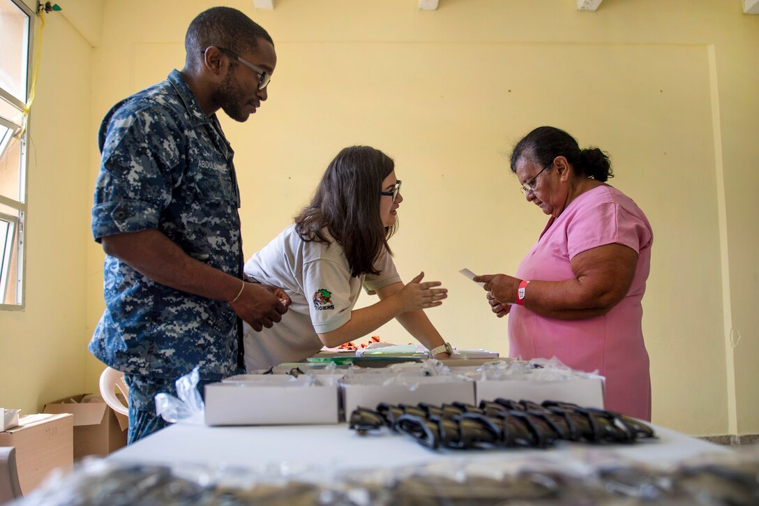 An American sailor speaks to a Honduran patient.