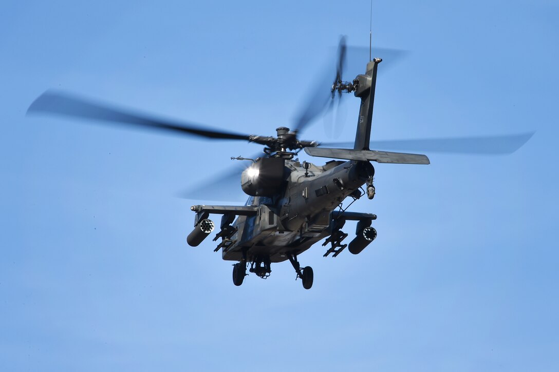 An AH-64D Apache Longbow helicopter provides aerial support.