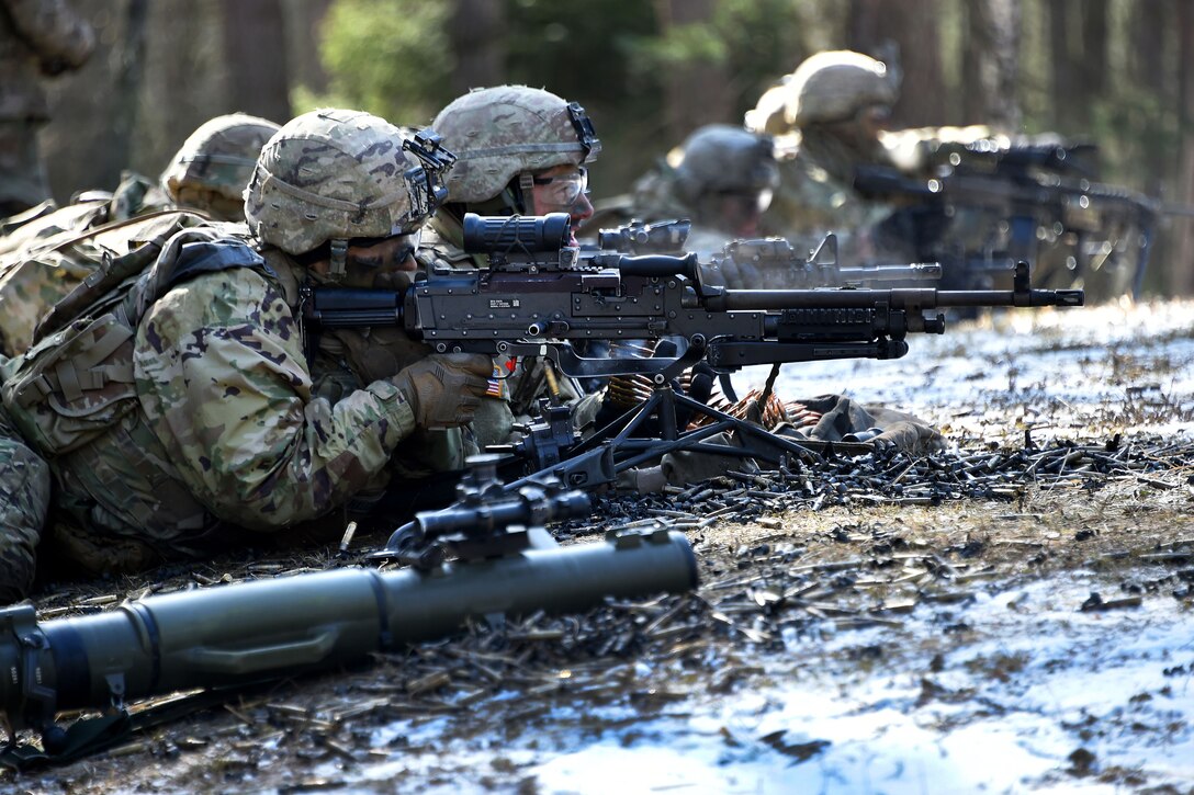 Soldiers fire their automatic weapons at targets.