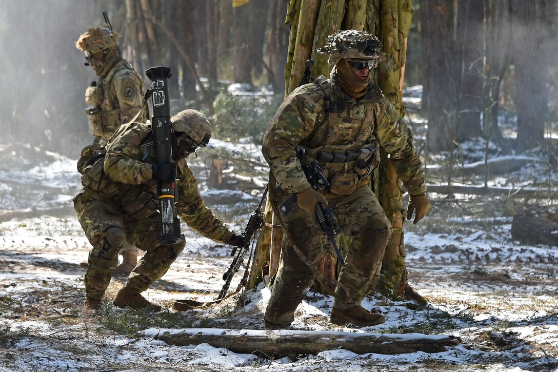 Soldiers move out after firing an AT-4 rocket launcher.