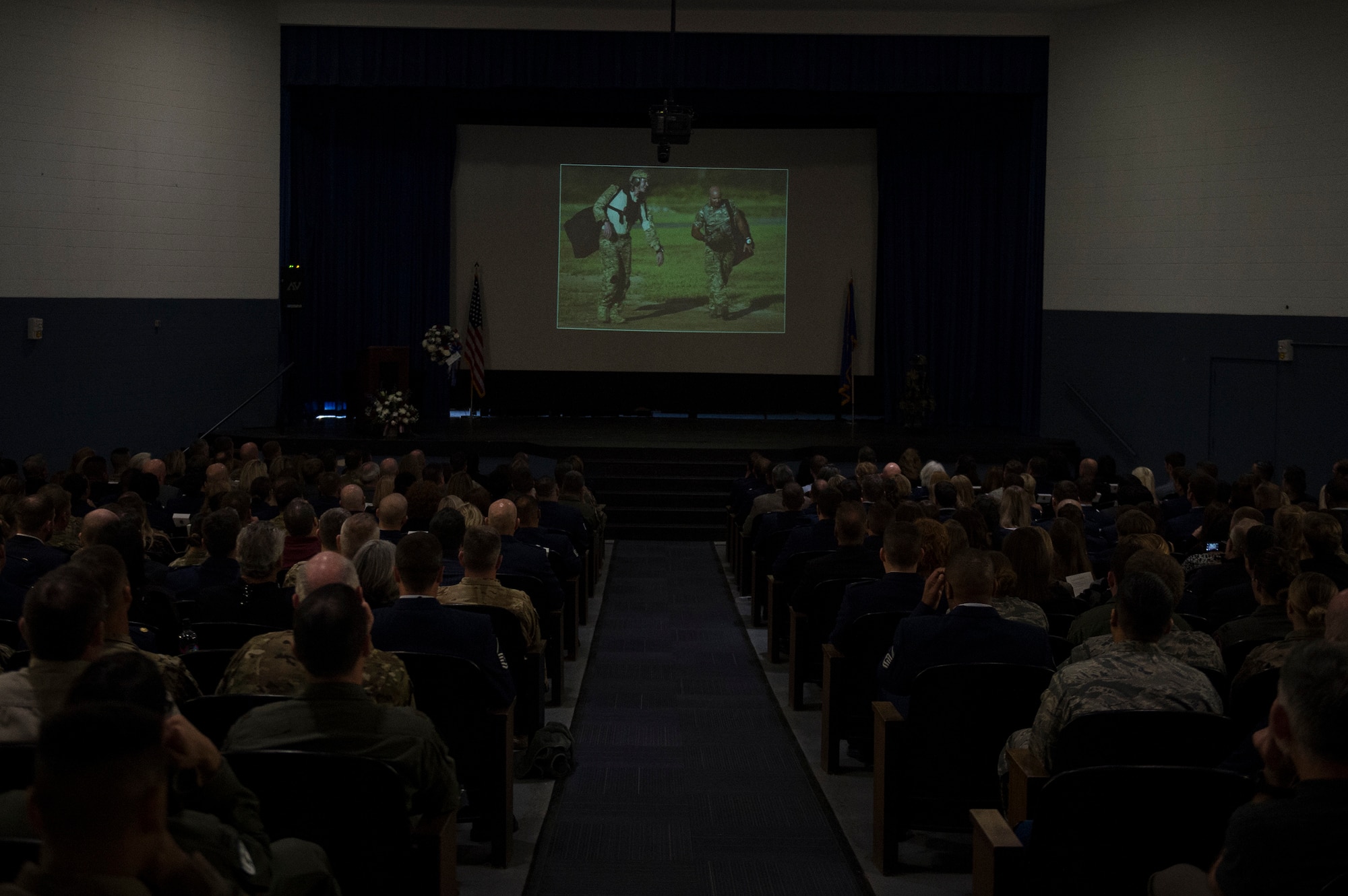 Guests watch a memorial service in honor of Capt. Mark Weber, March 21, 2018, at Moody Air Force Base, Ga. Weber, a 38th Rescue Squadron combat rescue officer and Texas native, was killed in an HH-60G Pave Hawk crash in Anbar Province, Iraq, March 15. During the ceremony, Weber was posthumously awarded a Meritorious Service Medal and the Air Force Commendation Medal. (U.S. Air Force photo by Andrea Jenkins)