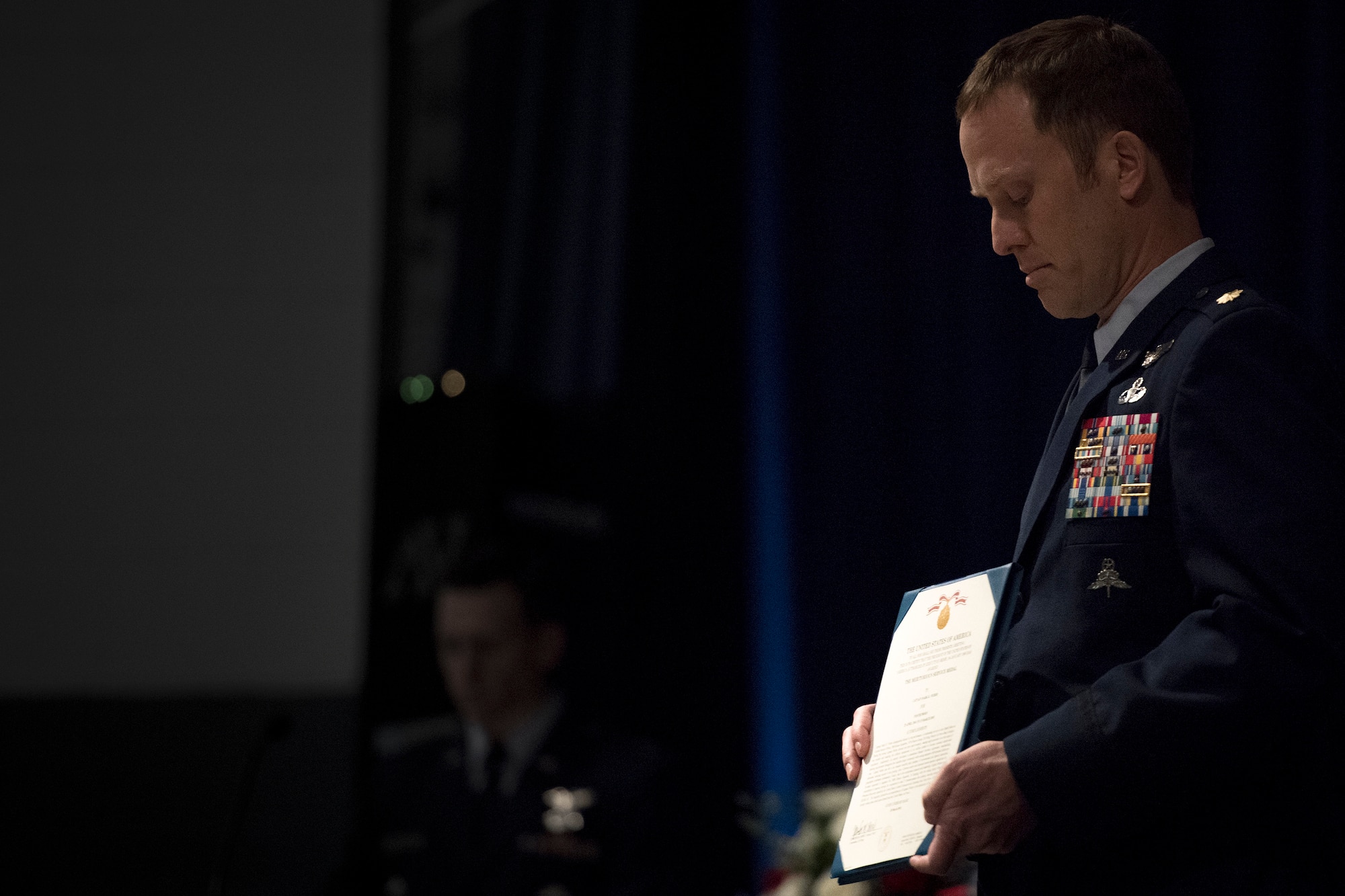 Maj. Jason Egger, 38th Rescue Squadron commander, presents a Meritorious Service Medal citation during a memorial service in honor of Capt. Mark Weber, March 21, 2018, at Moody Air Force Base, Ga. Weber, a 38th RQS combat rescue officer and Texas native, was killed in an HH-60G Pave Hawk crash in Anbar Province, Iraq, March 15. During the ceremony, Weber was posthumously awarded a Meritorious Service Medal and the Air Force Commendation Medal. (U.S. Air Force photo by Staff Sgt. Ryan Callaghan)