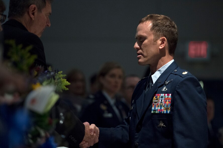 Maj. Jason Egger, 38th Rescue Squadron commander, shakes hands with Ron Weber, father of Capt. Mark Weber, during a memorial, March 21, 2018, at Moody Air Force Base, Ga. Mark, a 38th RQS combat rescue officer and Texas native, was killed in an HH-60G Pave Hawk crash in Anbar Province, Iraq, March 15. During the ceremony, Mark was posthumously awarded a Meritorious Service Medal and the Air Force Commendation Medal. (U.S. Air Force photo by Staff Sgt. Ryan Callaghan)