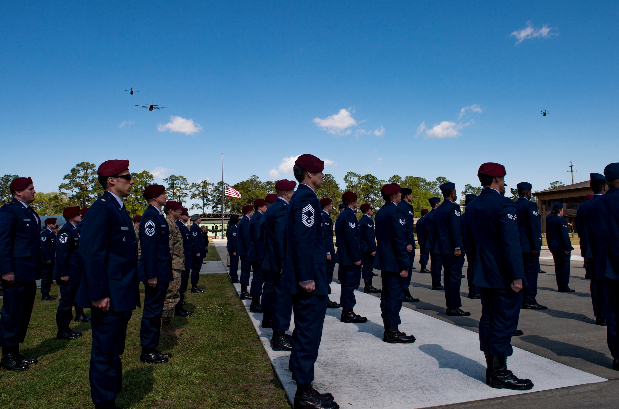 An HC-130J Combat King II and two HH-60G Pave Hawks fly over a formation of Airmen following a memorial service in honor of Capt. Mark Weber, March 21, 2018, at Moody Air Force Base, Ga. Weber, a 38th Rescue Squadron combat rescue officer and Texas native, was killed in an HH-60G Pave Hawk crash in Anbar Province, Iraq, March 15. During the ceremony, Weber was posthumously awarded a Meritorious Service Medal and the Air Force Commendation Medal. (U.S. Air Force photo by Andrea Jenkins)