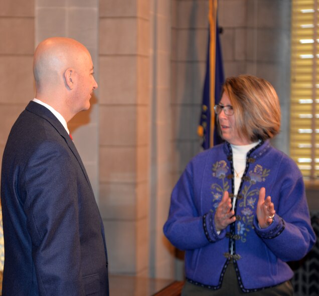 Julie Copley, spouse of Rear Adm. Curt Copley, U.S. Strategic Command (USSTRATCOM) Navy Element Commander and Director of Intelligence, discusses issues and challenges facing military spouses with Nebraska Gov. Pete Ricketts March 19, 2018, at the Nebraska State Capitol in Lincoln, Nebraska. Copley was on-hand, along with other Offutt-based military spouses, to witness the governor sign a rule change which will make it easier for military spouses to teach immediately if they have recently arrived from out of state.
