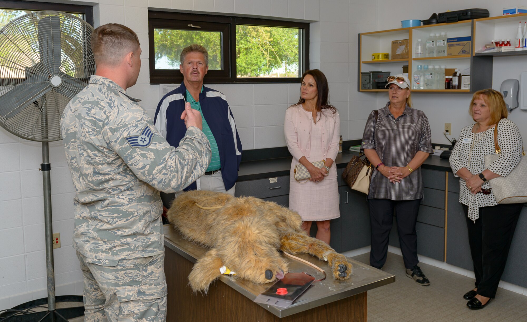 U.S. Air Force Tech Sgt. William Herron, 81st Security Forces Squadron military working dog handler, 
uses a mechanical dog to brief military dog care and first aid procedures to the Professional Golf Association Tour attendees during the players’ tour at the military working dog facility March 20, 2018, on Keesler Air Force Base, Mississippi. The attending golfers who are participating in the 2018 Rapiscan System Golf Classic also toured the 53rd Weather Reconnaissance Squadron and received a Science on a Sphere demonstration. (U.S. Air Force photo by André Askew)