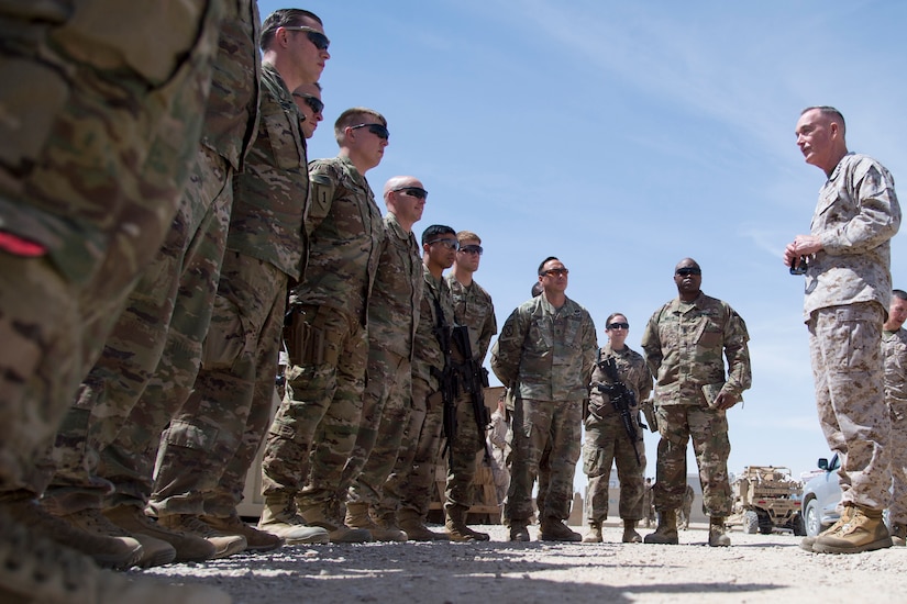 Marine Corps Gen. Joe Dunford talks to a group of soldiers standing outside.