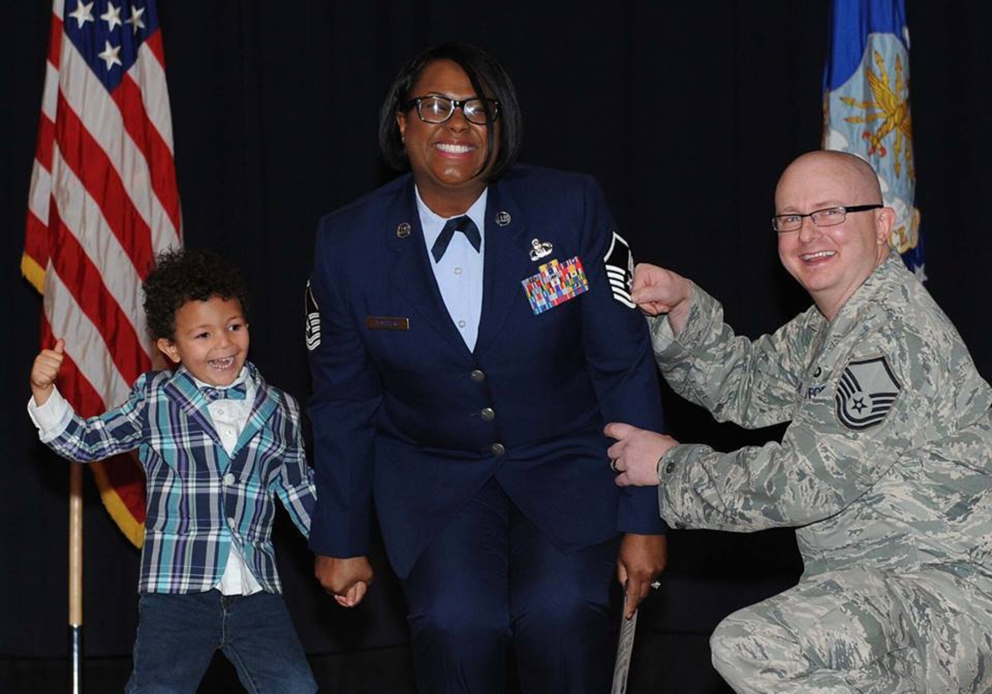Master Sgt. Ieaka Olmstead, 22nd Operations Support Squadron host aviation resource management superintendent, has her master sergeant stripes tacked on by her husband and son.