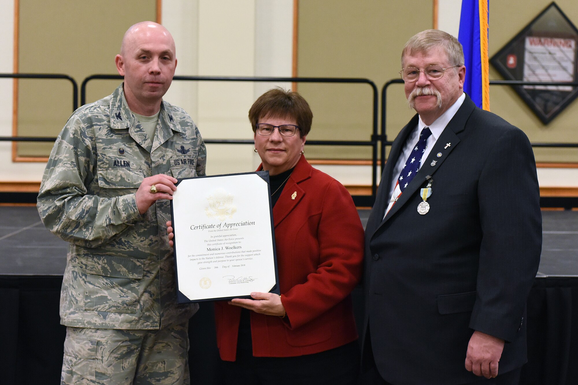 180228-F-UQ541-0657 Col. Ronald Allen, 341st Missile Wing commander, presents an award to and poses with Peter Woelkers Sr., 341st Missile Wing Weapons Safety Office chief of weapons safety/nuclear surety officer, and spouse Monica Woelkers, Feb. 28, 2018, at Malmstrom Air Force Base, Mont., during Peter’s retirement ceremony. Woelkers retired after a civilian career at Malmstrom that began in 1998. (U.S. Air Force photo by Kiersten McCutchan)