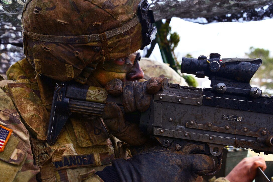 A soldier fires a machine gun.