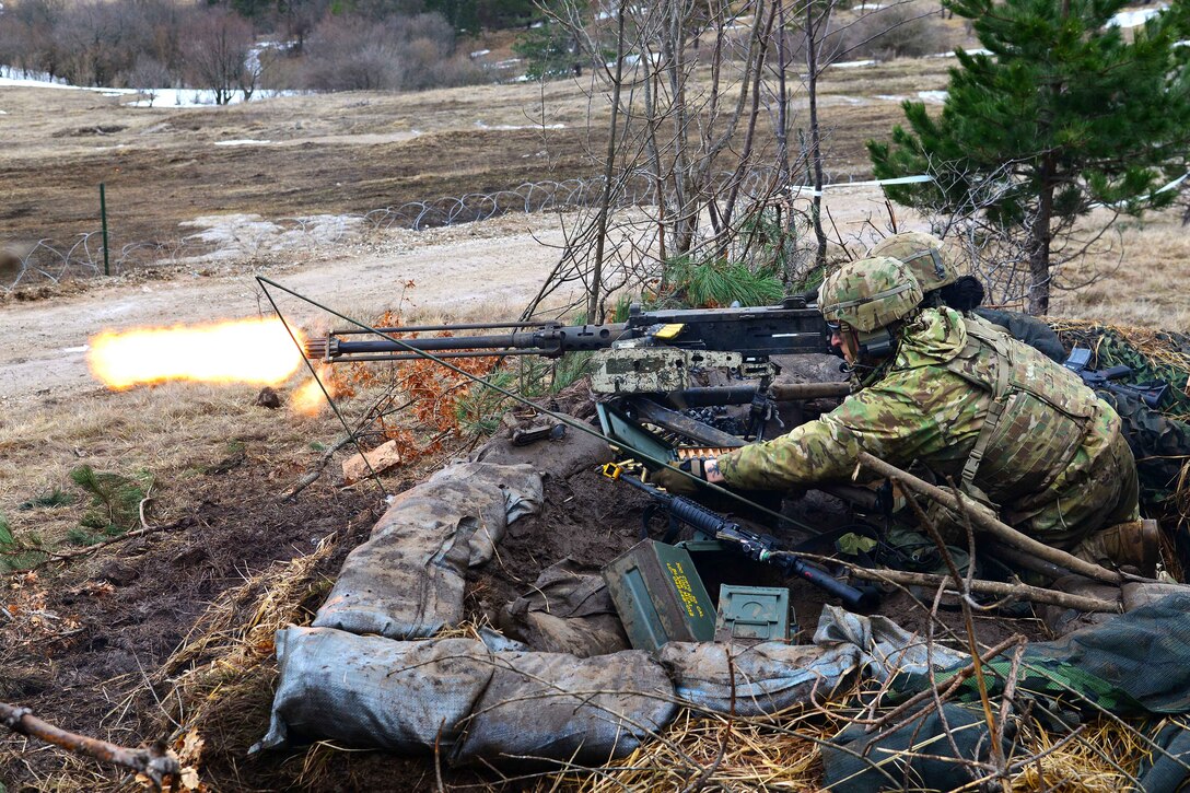 Soldiers fire an M2 machine gun.